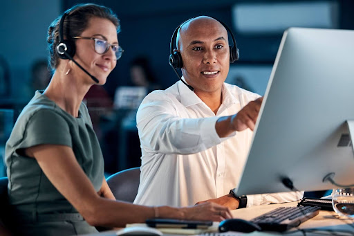 Two workers looking over medicare compliance on their computer.